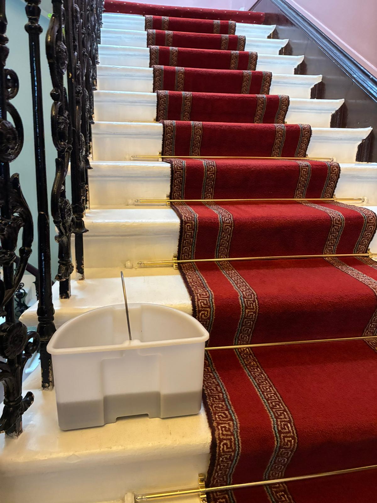 A finished red stair runner after a MERIT cleaning visit